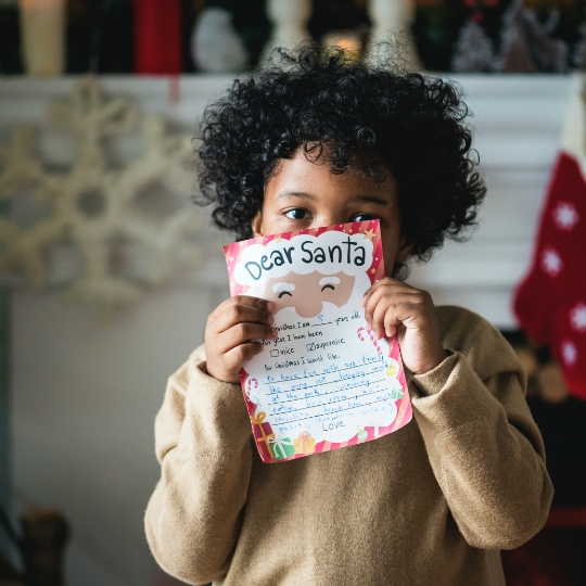 little boy holding a letter to santa