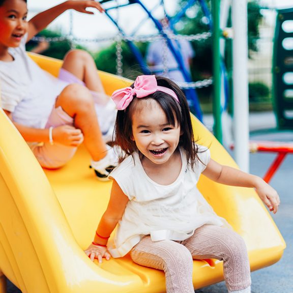 little girl going down slide at playground