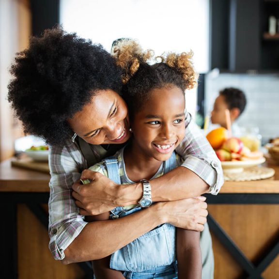 woman hugging a little girl in kitchen