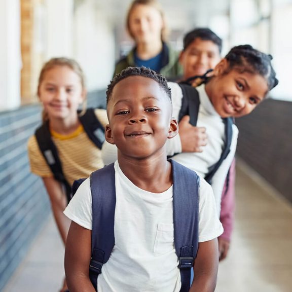 group of kids smiling in school hallway