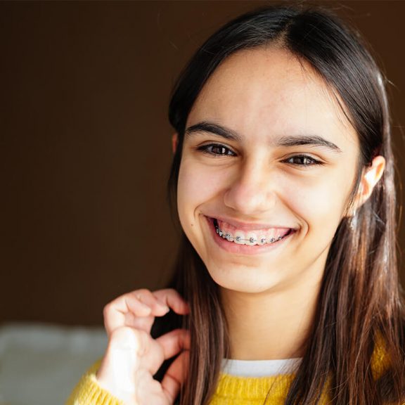 Young adult woman smiling with braces