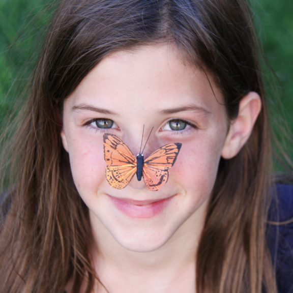 Young girl with butterfly on nose